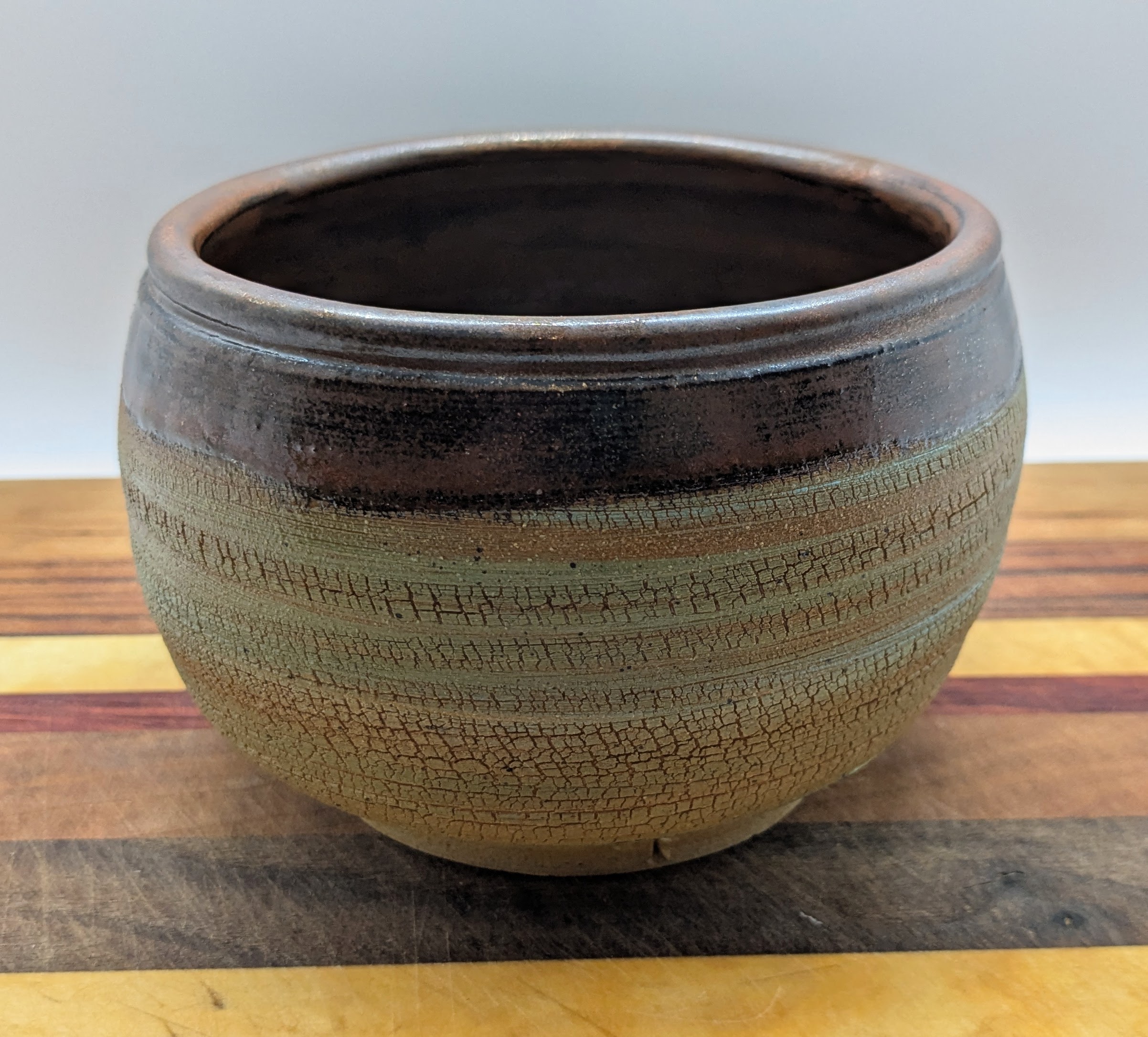 Small Crackle Bowl/Vase - This bowl was made using sodium silicate on the exterior to create its unique crackle texture. That texture is covered with lightly colored clay slip. An earthy copper color lines the bowl and exterior rim, leaving the rest of the exterior as bare clay. It can be used to stash trinkets, hold flowers or other decorative items, and is also food-safe. 

I recommend handwashing this piece. - 30